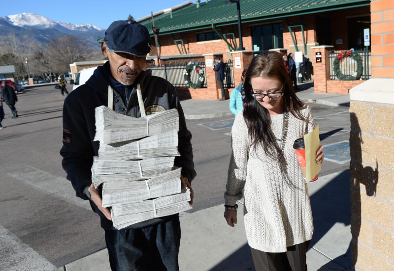 Raven Canon, right, walks with Jerome Freeman as he carries copies the first edition of the newspaper Friday, December 30, 2016. Photo by Mark Reis, The Gazette.