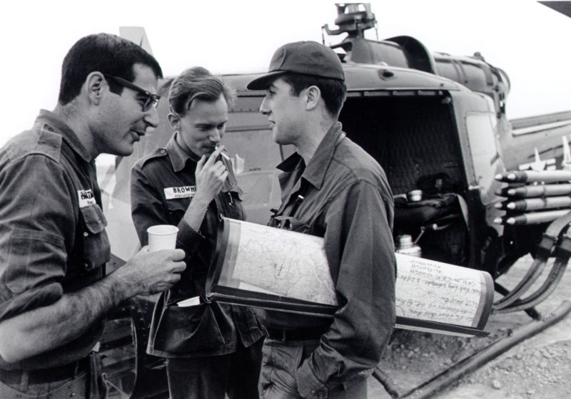In this undated photo taken in the early to mid-1960s, from left to right, reporters David Halberstam of The New York Times, AP Saigon correspondent Malcolm Brown, and Neil Sheehan of UPI chat beside a helicopter in Vietnam. (AP Photo)