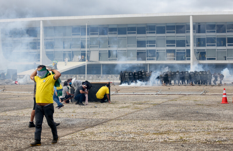 Pedro Ladeira captured clashes between protestors and police, as Bolsonaro supporters look on from inside teh stormed Brazilian Congress building in Brasília.Photo: Pedro Ladeira/Folhapress